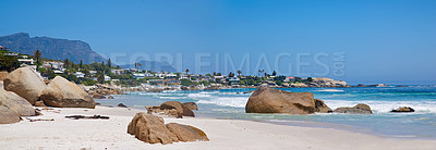 Buy stock photo Seascape scenic view of a rocky beach with crystal blue waters and clear sunny weather skies. A popular tourist location during summer. Beautiful seashore on Camps Bay, Cape Town, South Africa  