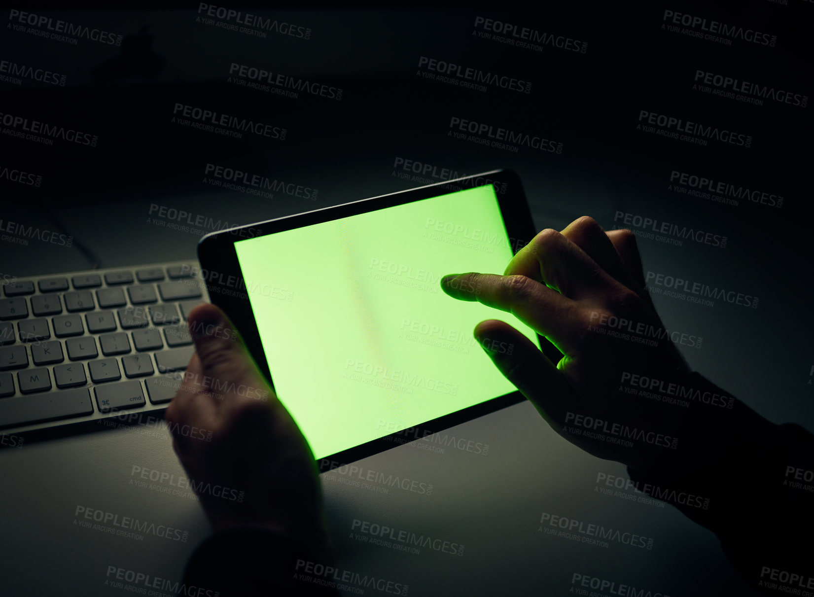 Buy stock photo Cropped shot of an unrecognizable man using a tablet in the dark