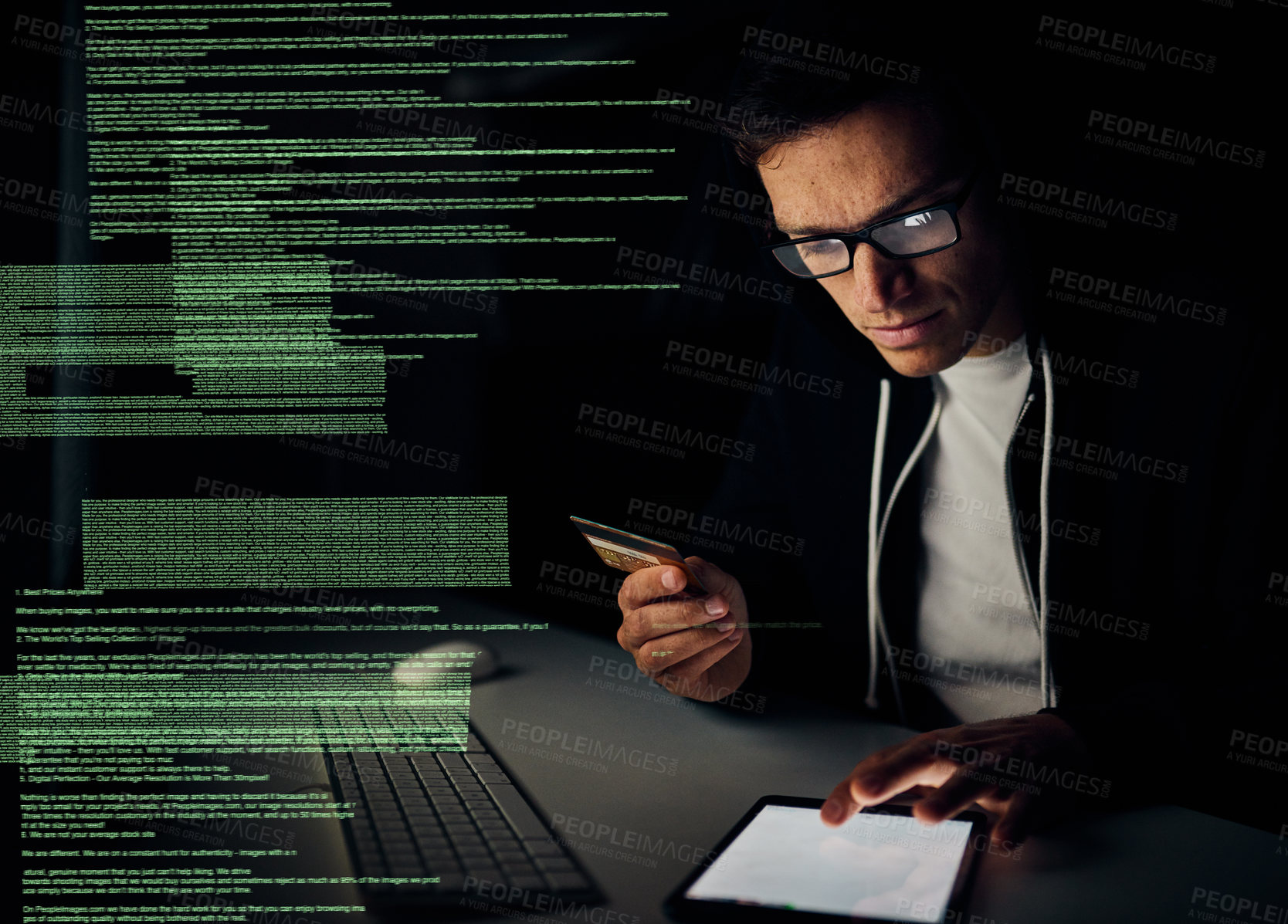 Buy stock photo Cropped shot of a young hacker using a tablet to commit credit card fraud in the dark