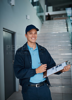 Buy stock photo Cropped shot of a handsome young man marking off his checklist on a clipboard indoors