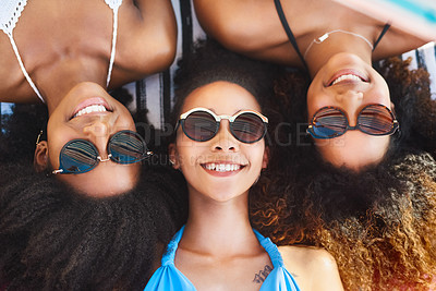 Buy stock photo High angle Portrait of a group of happy young women wearing sunglasses and relaxing at the beach