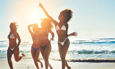 Buy stock photo Shot of a group of happy young women having fun together at the beach