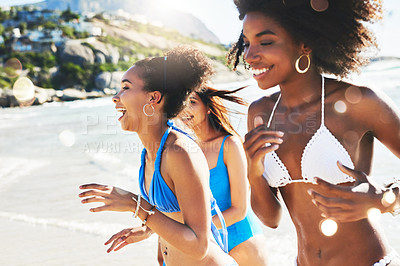 Buy stock photo Shot of a group of happy young women having fun together at the beach