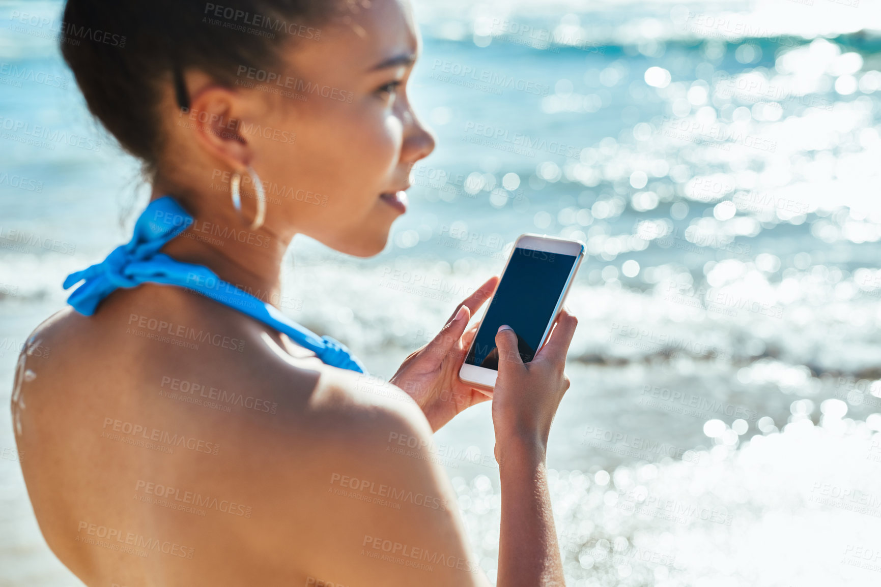 Buy stock photo Woman, phone and screen vacation by sea, typing and outdoor travel for ocean communication. Female person, media surfing and online for social update by waves, nature and thinking on holiday in Bali