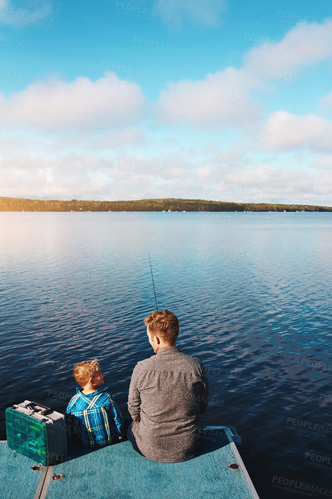 Buy stock photo Shot of a father and his young son out fishing by the lake