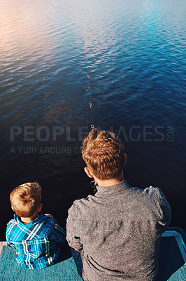 Buy stock photo Shot of a father and his young son out fishing by the lake
