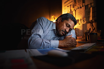 Buy stock photo Shot of a mature businessman sleeping at his desk while working late in an office