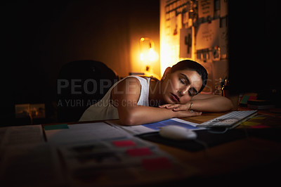 Buy stock photo Shot of a young businesswoman sleeping at her desk while working late in an office