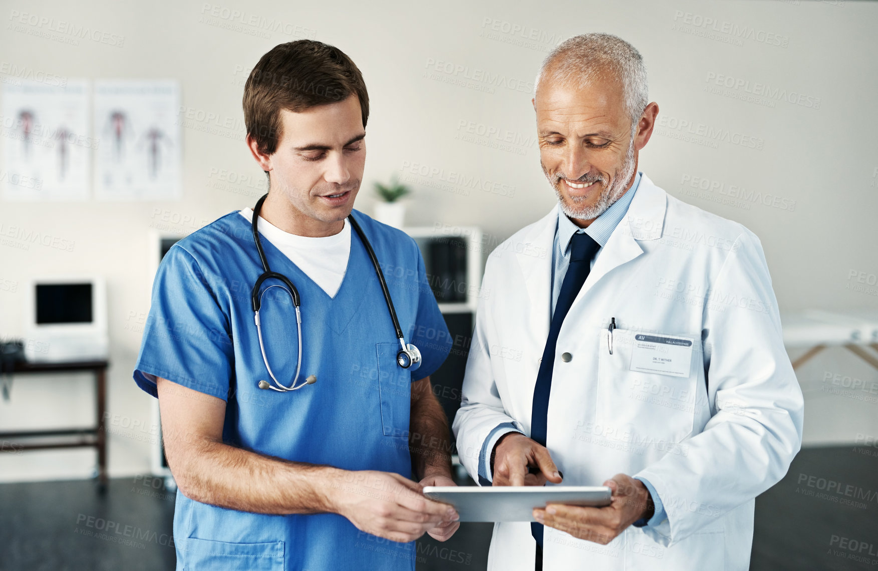 Buy stock photo Shot of two medical practitioners using a digital tablet in a hospital