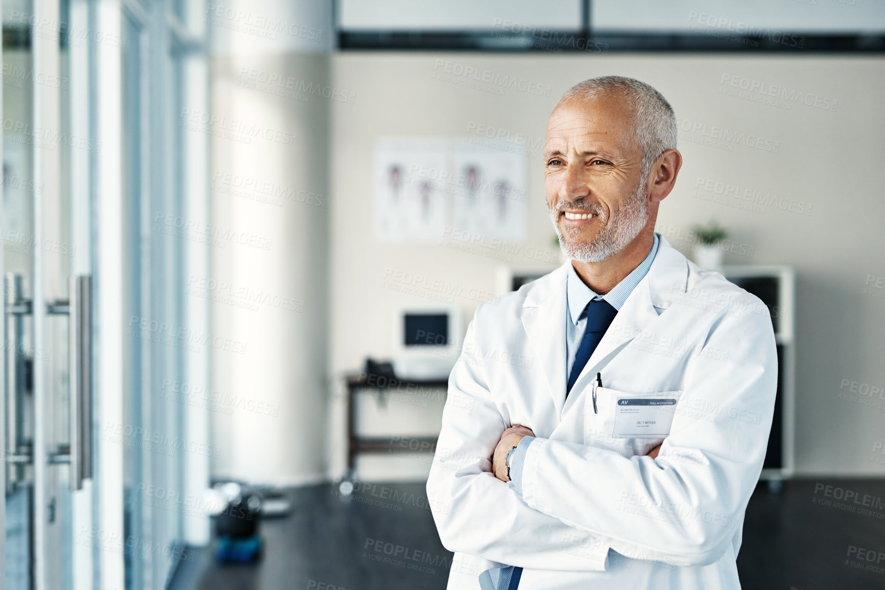 Buy stock photo Shot of a mature doctor standing in a hospital