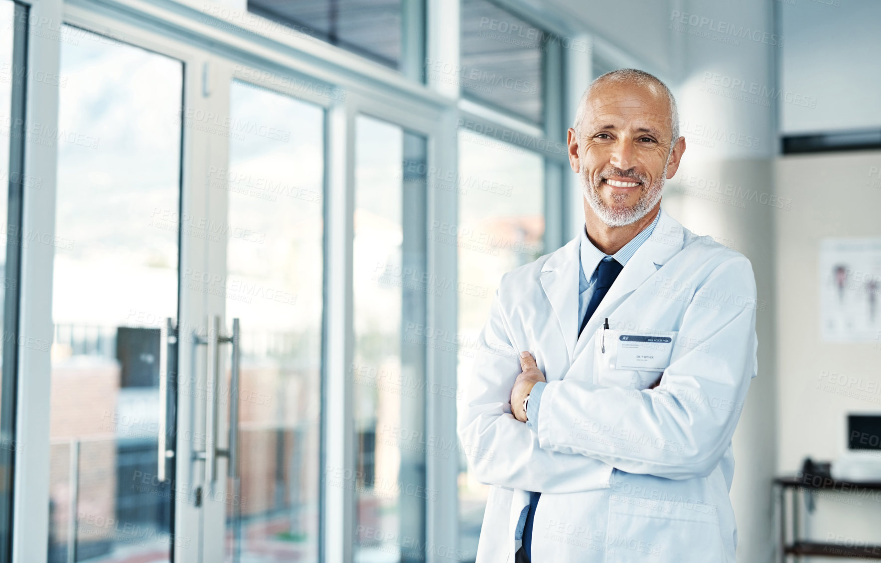 Buy stock photo Mature doctor, leadership and portrait with arms crossed in hospital feeling proud from medical work. Healthcare, wellness and professional employee with happiness from health support and job