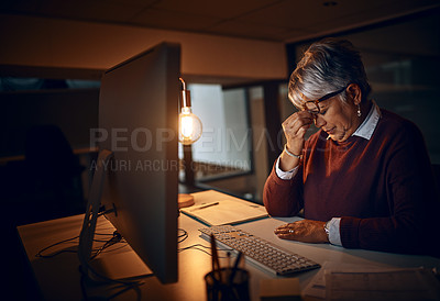 Buy stock photo Anxiety, night and mature businesswoman at desk by computer for fatigue, overtime or project deadline in office. Headache, publishing agency and employee for exhausted, stress or burnout in dark