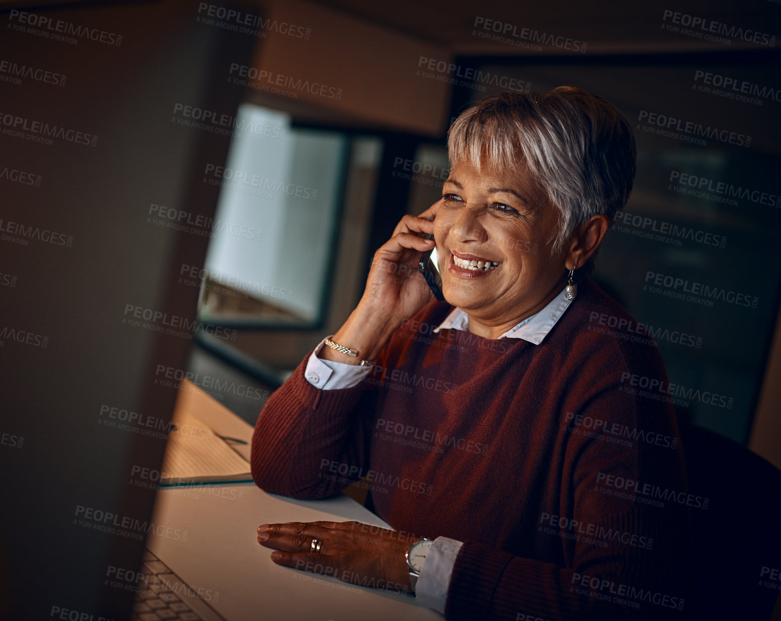 Buy stock photo Night, mature woman and call in office for business, communication and contact. Dark, happy and lady at desk with phone, scheduling and chatting on mobile for funny story or gossip on late shift