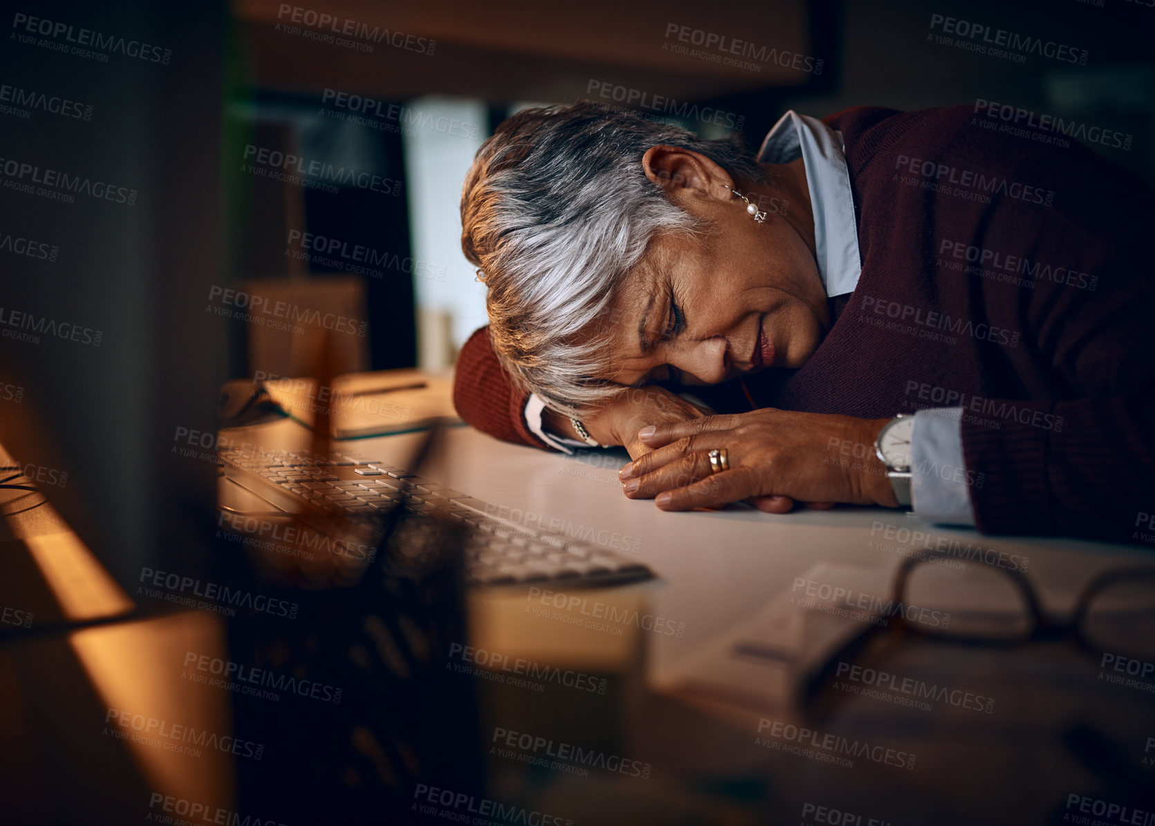 Buy stock photo Shot of a mature businesswoman sleeping at her desk while working late in an office