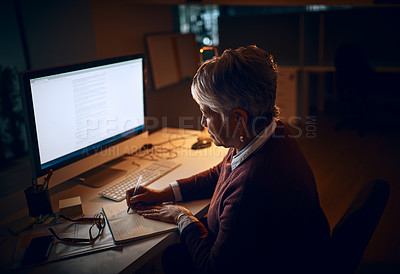 Buy stock photo Shot of a mature businesswoman working late in an office