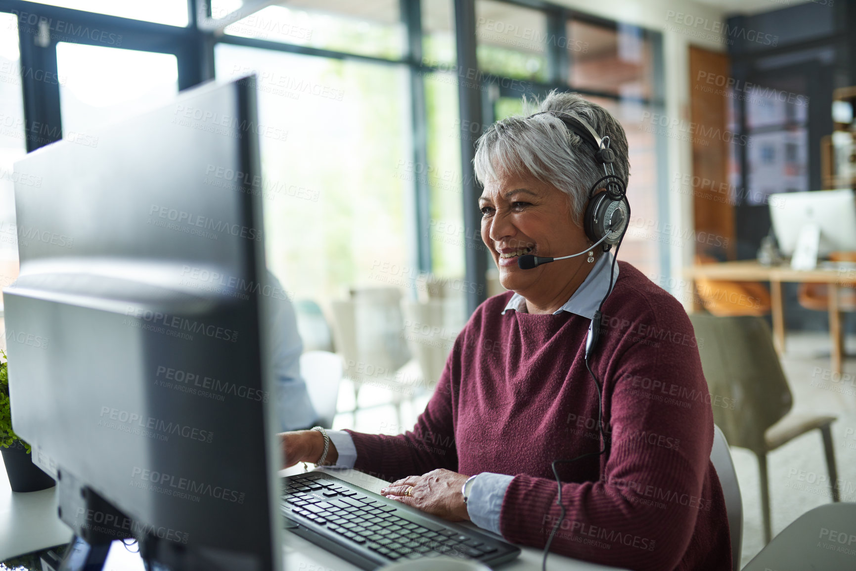 Buy stock photo Shot of a mature woman working on a computer in a call centre