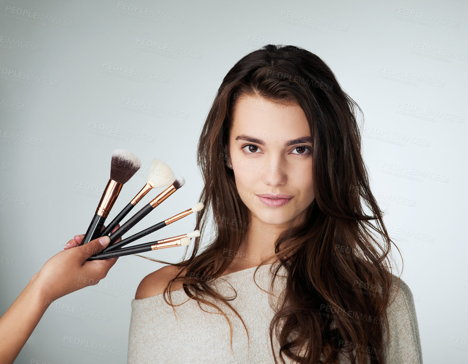 Buy stock photo Woman, beauty and makeup brush for face in studio with a natural glow. Portrait of female person on a grey background with a hand for cosmetology transformation, powder cosmetics and facial skin care