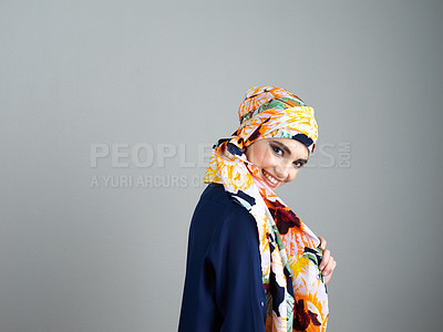 Buy stock photo Studio portrait of a confident young woman wearing a colorful head scarf while posing against a grey background