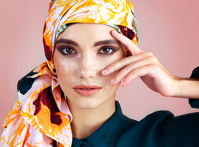 Buy stock photo Studio portrait of a confident young woman wearing a colorful head scarf while posing against a pink background