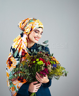 Buy stock photo Woman, turban and bouquet for beauty in studio, spring or nature with thinking by background. Person, girl or model for floral plants, leaves and headscarf with makeup, style and sustainable fashion