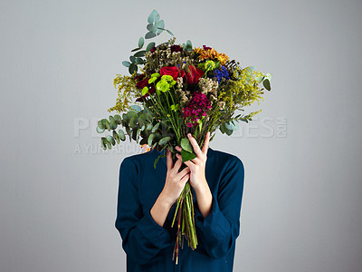 Buy stock photo Person, hide and bouquet of flowers in studio with mystery, nature and gift in spring by background. Model, hands and floral present with leaves, celebration and plants to cover face with beauty