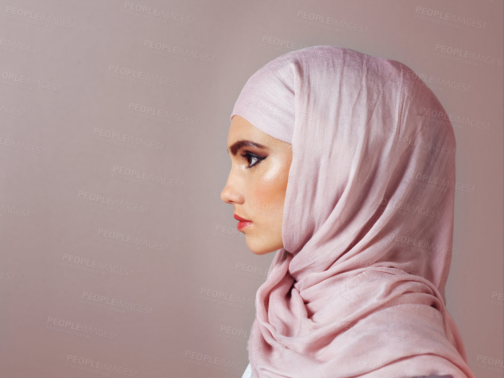 Buy stock photo Studio shot of a confident young woman wearing a colorful head scarf while posing against a grey background