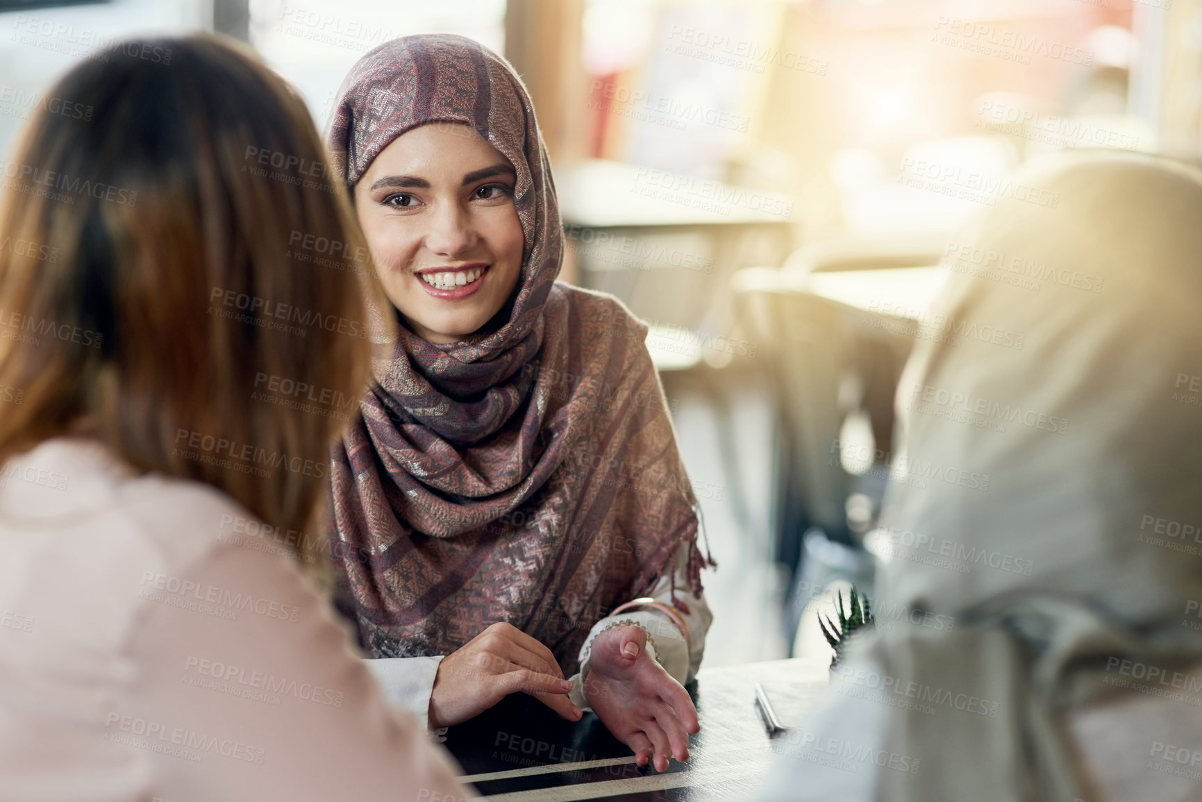 Buy stock photo Friends, happy and Muslim women in cafe, bonding and talking together. Coffee shop, smile and Islamic girls, group or people chat, conversation and discussion for social gathering in restaurant.