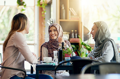 Buy stock photo Friends, funny and Muslim women in cafe, bonding and talking together. Coffee shop, happy and Islamic girls, group or people laughing, conversation and discussion for social gathering in restaurant.