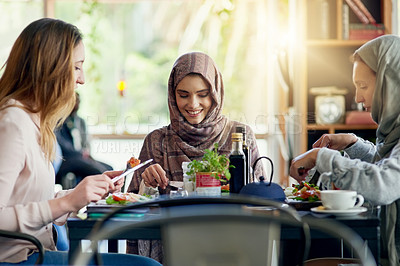 Buy stock photo Muslim women, friends and eating in restaurant, together and talking with food, smile or happiness. Islamic woman, group and brunch with conversation, happy face or listening with social chat in cafe
