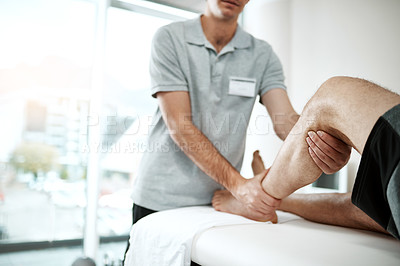 Buy stock photo Shot of an unrecognizable male physiotherapist helping a client with leg exercises who's lying on a bed