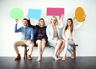 Buy stock photo Shot of a group of work colleagues seated next to each other while holding speech bubbles against a white background
