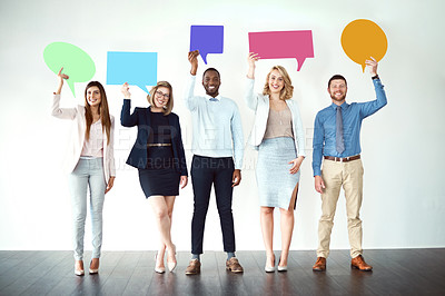 Buy stock photo Shot of a group of work colleagues standing next to each other while holding speech bubbles against a white background