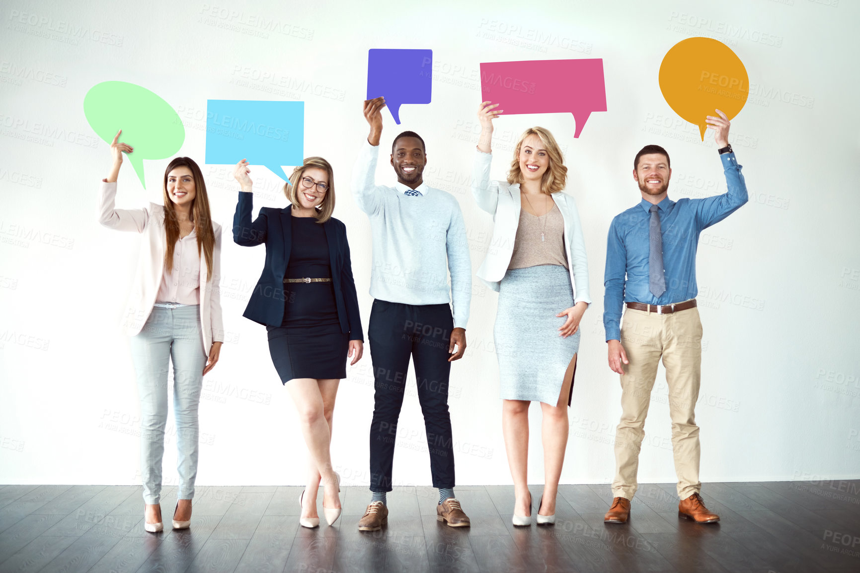 Buy stock photo Shot of a group of work colleagues standing next to each other while holding speech bubbles against a white background