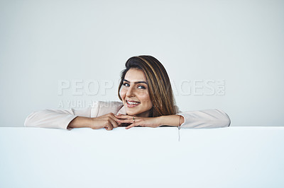 Buy stock photo Studio shot of an attractive young businesswoman behind a blank placard