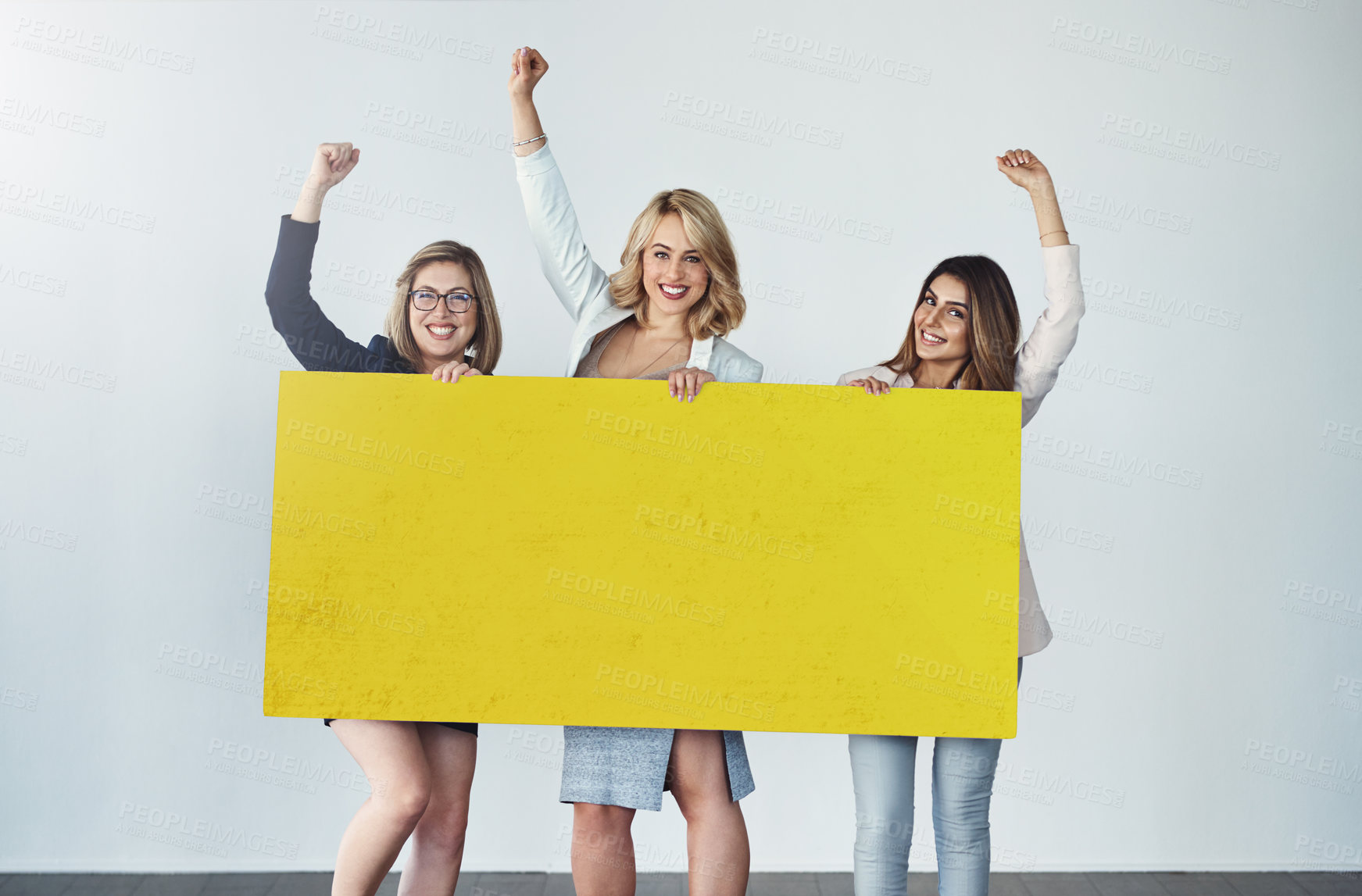Buy stock photo Studio shot of a group of businesswomen holding up a blank yellow placard and cheering