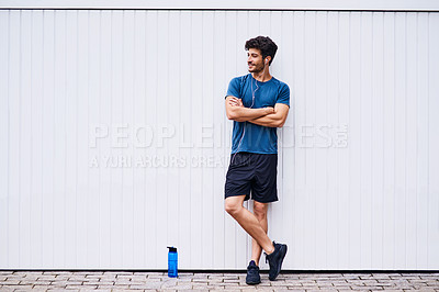 Buy stock photo Shot of a sporty young man standing against a white wall
