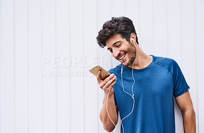 Buy stock photo Earphones, fitness and man with cellphone, wall and happiness with motivational podcast. Smile, healthy person and athlete with smartphone, radio and online for audio, exercise and workout with music