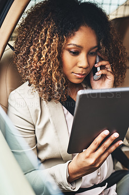 Buy stock photo Shot of an attractive businesswoman on a call and using a tablet during her morning commute