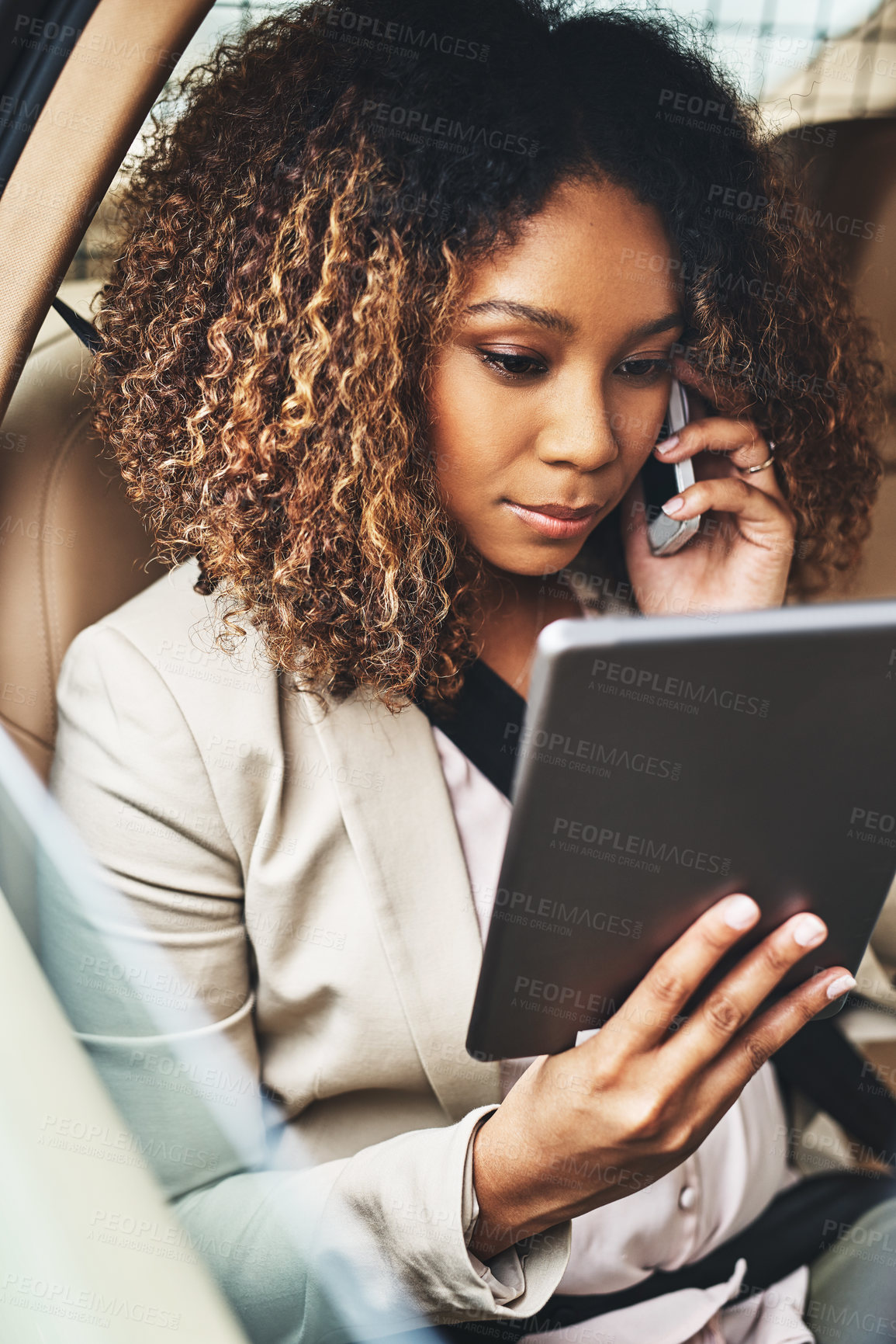 Buy stock photo Shot of an attractive businesswoman on a call and using a tablet during her morning commute