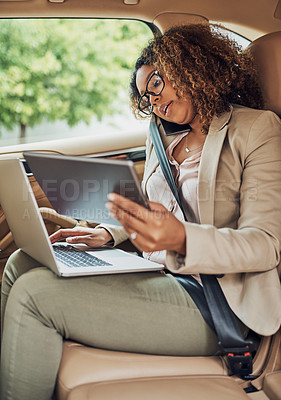 Buy stock photo Shot of an attractive businesswoman on a call while using a tablet and laptop during her morning commute