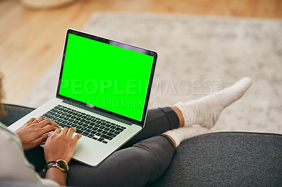 Buy stock photo Shot of an unrecognizable woman working on a laptop while being seated on the couch at home