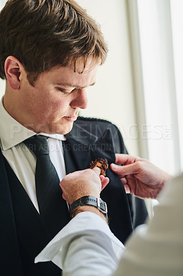 Buy stock photo Shot of a confident young man receiving a pendant from an unrecognizable person at a wedding during the day