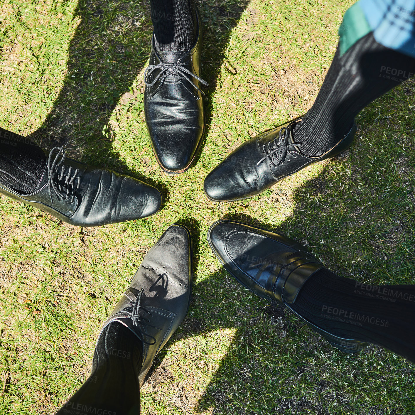 Buy stock photo Shot of a group of unrecognizable men's formal dress shoes standing next to each other in a circle outside during the day