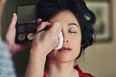 Buy stock photo Shot of a confident young woman seated with her eyes closed while getting makeup done before a wedding