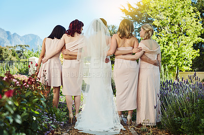 Buy stock photo Rearview shot of a young bride and her bride's maids standing together outside during the day