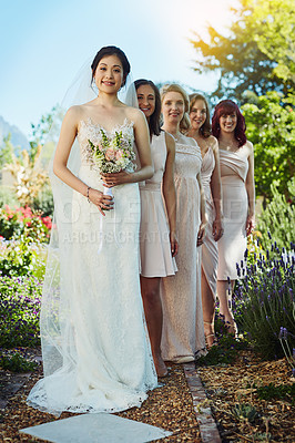 Buy stock photo Portrait of a cheerful young bride and her bride's maids standing together outside during the day