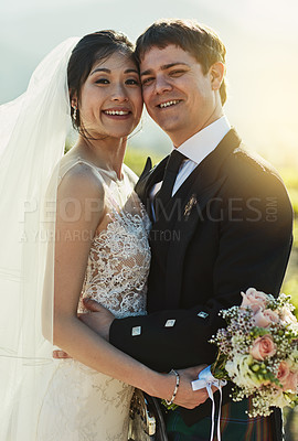 Buy stock photo Portrait of a cheerful young bride and groom holding each other while standing outside on a farm