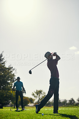 Buy stock photo Shot of a focused young male golfer about to swing and play a shot with his golf club outside on a course