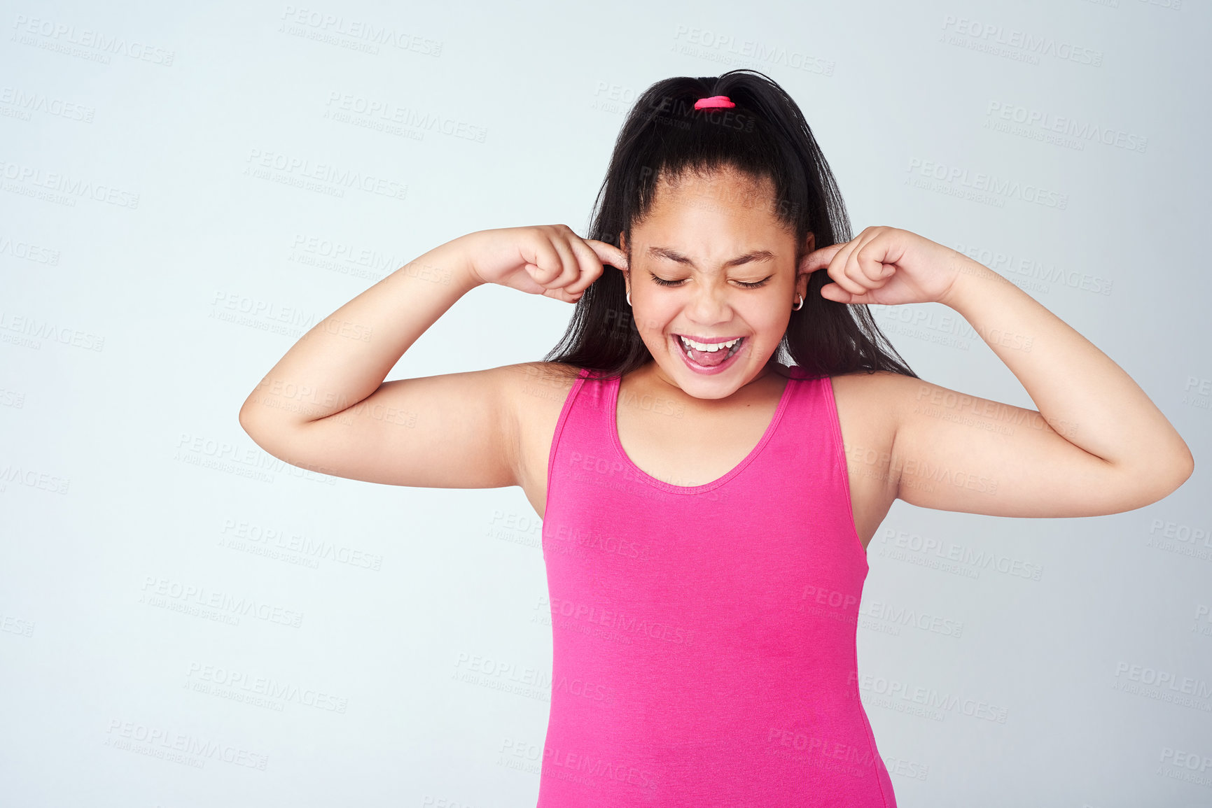 Buy stock photo Studio shot of a cute young girl with her fingers in her ears against a gray background