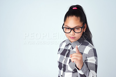 Buy stock photo Portrait, finger and girl with attitude, serious face and hand gesture on grey studio background. Kid, child and body language with review, feedback and nonverbal communication with emoji and warning
